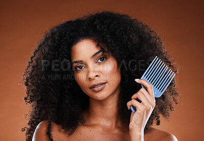 Hair, comb and beauty with a black woman model in studio on a black background for haircare or treatment. Portrait, face and afro with an attractive young female posing to promote keratin hair care