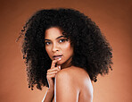 Beauty, makeup and portrait of a black woman with an afro against a brown studio background. Skincare, wellness and face of an African cosmetics model with a glow on body from luxury cosmetology