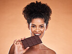 Chocolate, happy woman and beauty portrait, studio background and eating sweets, cacao dessert and enjoy sugar. Black woman bite chocolate bar, cocoa and candy, diet calories and snack temptation 