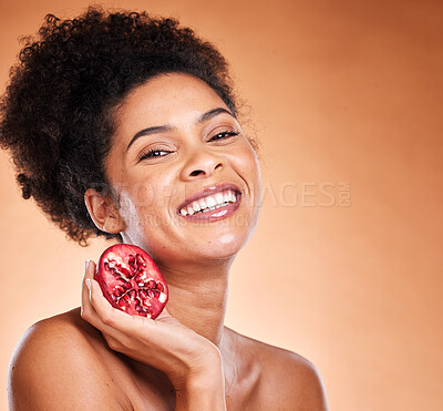 Buy stock photo Black woman, pomegranate fruit and skincare spa wellness for beauty or hair healthcare. Cosmetics, vitamin or happy african model smile for nutrition lifestyle portrait in brown studio background