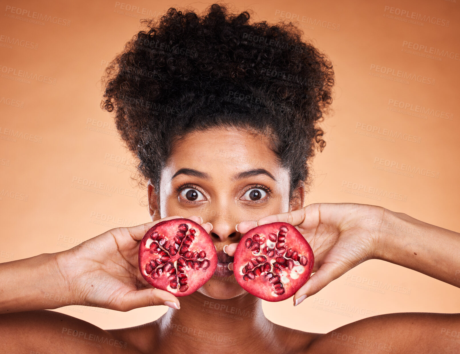 Buy stock photo Black woman beauty, pomegranate and face in skincare portrait with fruit in by orange background. African model, woman and cosmetics studio for health, natural makeup and nutrition for skin wellness