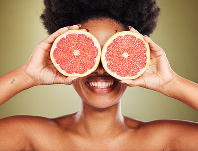 Buy stock photo Skincare, wellness and black woman with grapefruit and smile in studio for healthy lifestyle. Beauty, creative and happy girl with fruit over eyes marketing organic, natural and fresh beauty products