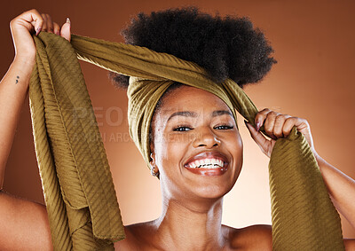 Buy stock photo Beauty, black woman and portrait with afro hair wrap for protection, style and african fashion. Natural, happy and healthy hair care of skincare model on brown studio background with smile.

