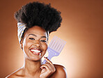 Hair care, beauty and black woman with afro comb for a routine in studio with mockup space. Happy, smile and portrait of young African model with natural hair and product isolated by brown background