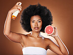 Black woman, hair care and beauty with spray, studio or wellness in portrait, health or afro with grapefruit. Woman, model and african girl with fruit, cosmetics or self care with by brown background