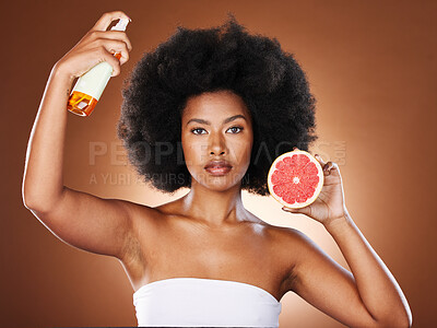 Buy stock photo Black woman, hair care and beauty with spray, studio or wellness in portrait, health or afro with grapefruit. Woman, model and african girl with fruit, cosmetics or self care with by brown background