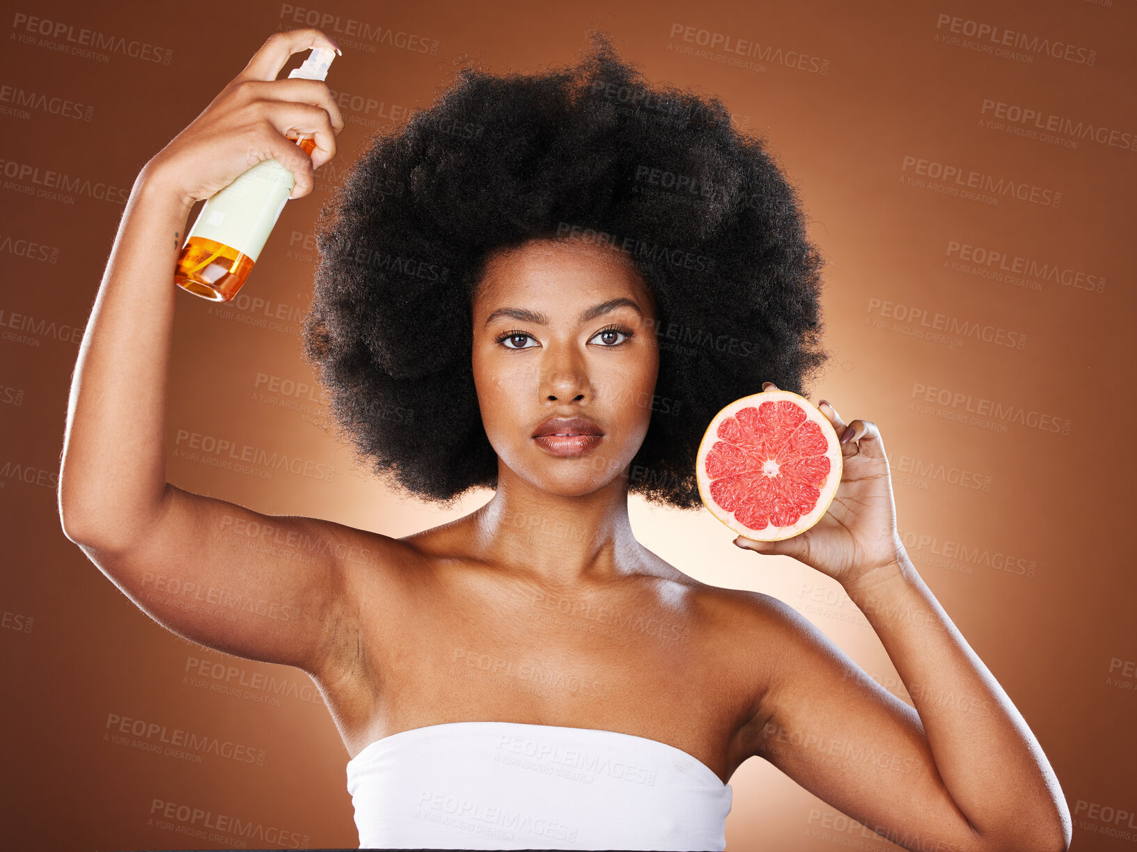 Buy stock photo Black woman, hair care and beauty with spray, studio or wellness in portrait, health or afro with grapefruit. Woman, model and african girl with fruit, cosmetics or self care with by brown background