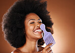 Curly hair, beauty comb and black woman, afro hairstyle and cosmetics of hair salon perm on studio background. Portrait happy african, hair brush and natural hair care, fashion and big hair style 