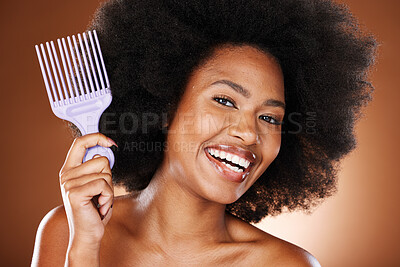 Buy stock photo Happy black woman, hair care and comb in portrait with afro pick, beauty and self care by brown backdrop. African woman, model and cosmetics with makeup or happiness for combing by studio background