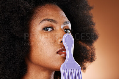 Buy stock photo Beauty, skincare or black woman with comb on mouth portrait for hair fashion, wellness or cosmetics in orange background studio. Face, zoom or model girl with afro ,glow skin, natural healthcare