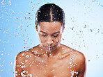Woman, water or splash with skincare for beauty, moisturizer or self care by blue background. Black woman, model and skin for cosmetics, wellness or dermatology health by cosmetic backdrop in studio