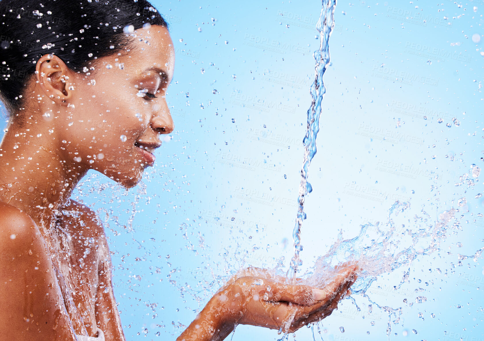 Buy stock photo Water, splash and black woman doing skincare for health, wellness and hygiene in a studio. Beauty, shower and girl model doing a natural treatment for skin, body or face with aqua by blue background.