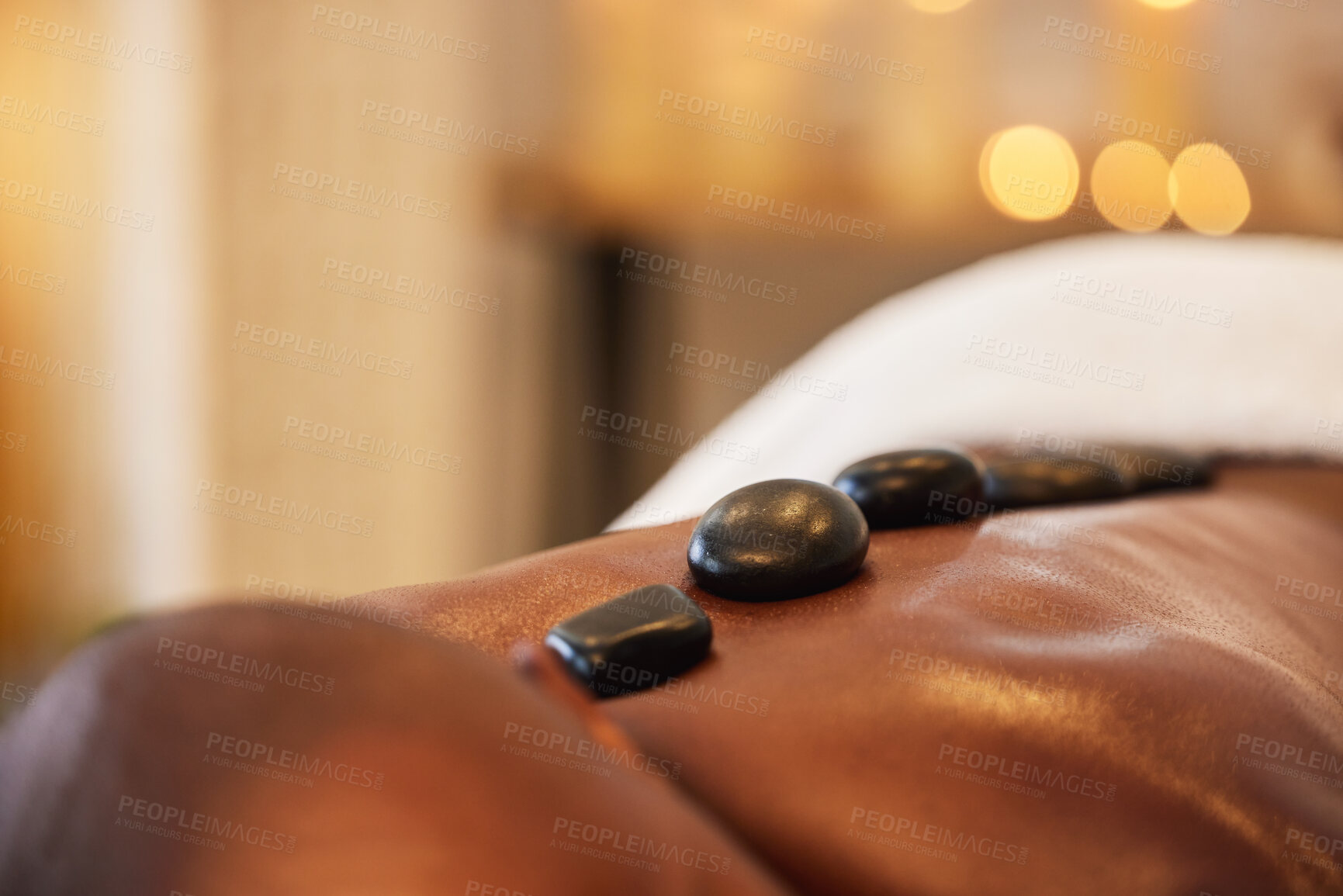 Buy stock photo Back, man and hot stone massage in a beauty spa for muscle relaxation and health or wellness. Bodycare, hot rock  massage in a zen spa for beauty, for man body care and spa massage with stones