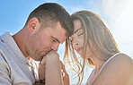 Love, hand and couple kiss at a beach, sharing intimate moment of romance at sunrise against blue sky background. Travel, freedom and man with woman embrace, care and relax in nature together mockup