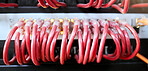 Technology, server room and cables connected to ethernet port or router for network, internet or fiber in data center for connection management. Electrical red optic cable for computer it background