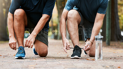 Buy stock photo Fitness, run and men friends tying their shoes while doing an outdoor cardio workout in the city. Sports, footwear and male athletes running for exercise or training for marathon, race or competition