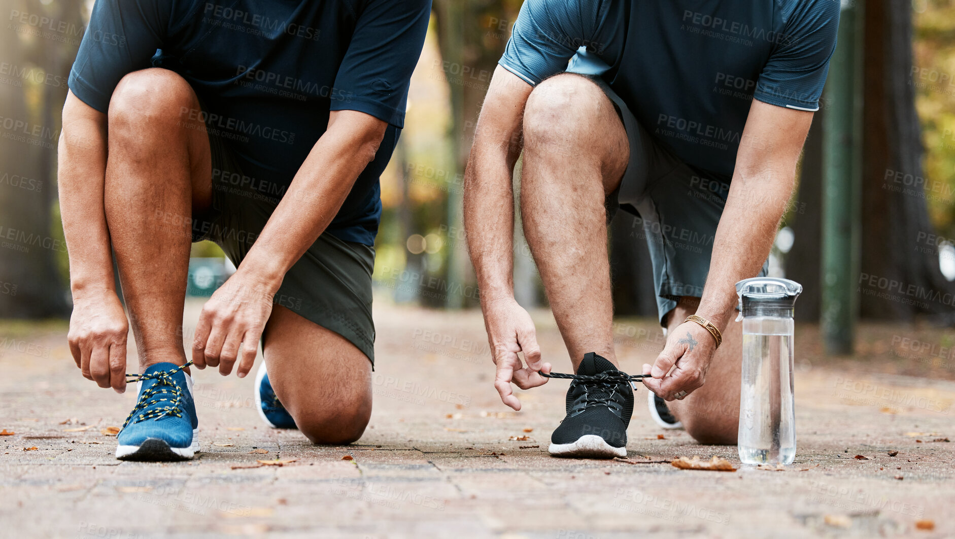 Buy stock photo Fitness, run and men friends tying their shoes while doing an outdoor cardio workout in the city. Sports, footwear and male athletes running for exercise or training for marathon, race or competition