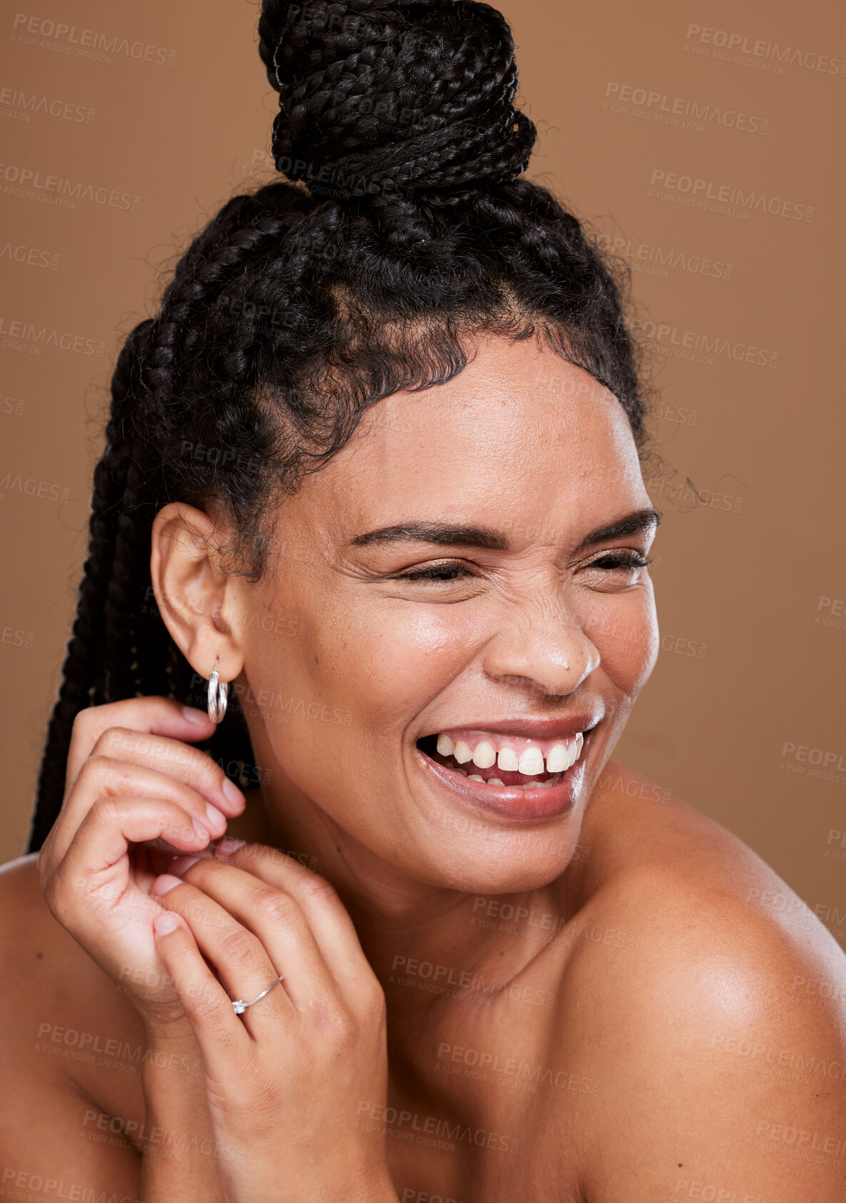 Buy stock photo Makeup, marketing and woman laughing for cosmetics, skincare and self care against a brown studio background. Relax, comic and model with comedy from beauty, dermatology and advertising of body glow