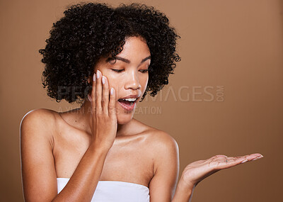 Buy stock photo Skincare, girl and surprise hand product placement with wow, excited and healthy beauty face. Natural, facial and hair care of black woman in brown studio mockup for cosmetics advertising.



