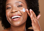 Skincare, face cream and woman in studio for wellness, beauty and cleaning against brown background. Portrait, black woman and sunscreen product on face for luxury, facial and dermatology with mockup