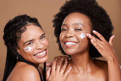 Buy stock photo Beauty, friends and black women with face cream for skincare or moisturizing in studio on brown background. Smile, group portrait and models apply facial product or cosmetics creme for healthy skin.
