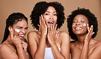 Skincare, beauty and black women, friends and face cream in studio on brown background. Group portrait, smile and happy models apply facial lotion or cosmetics product for moisturizing healthy skin.

