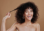 Hair care, growth and woman excited about health, wellness and clean shampoo against a brown studio background. Salon, smile and portrait of a model with hair beauty and shine from hairdresser