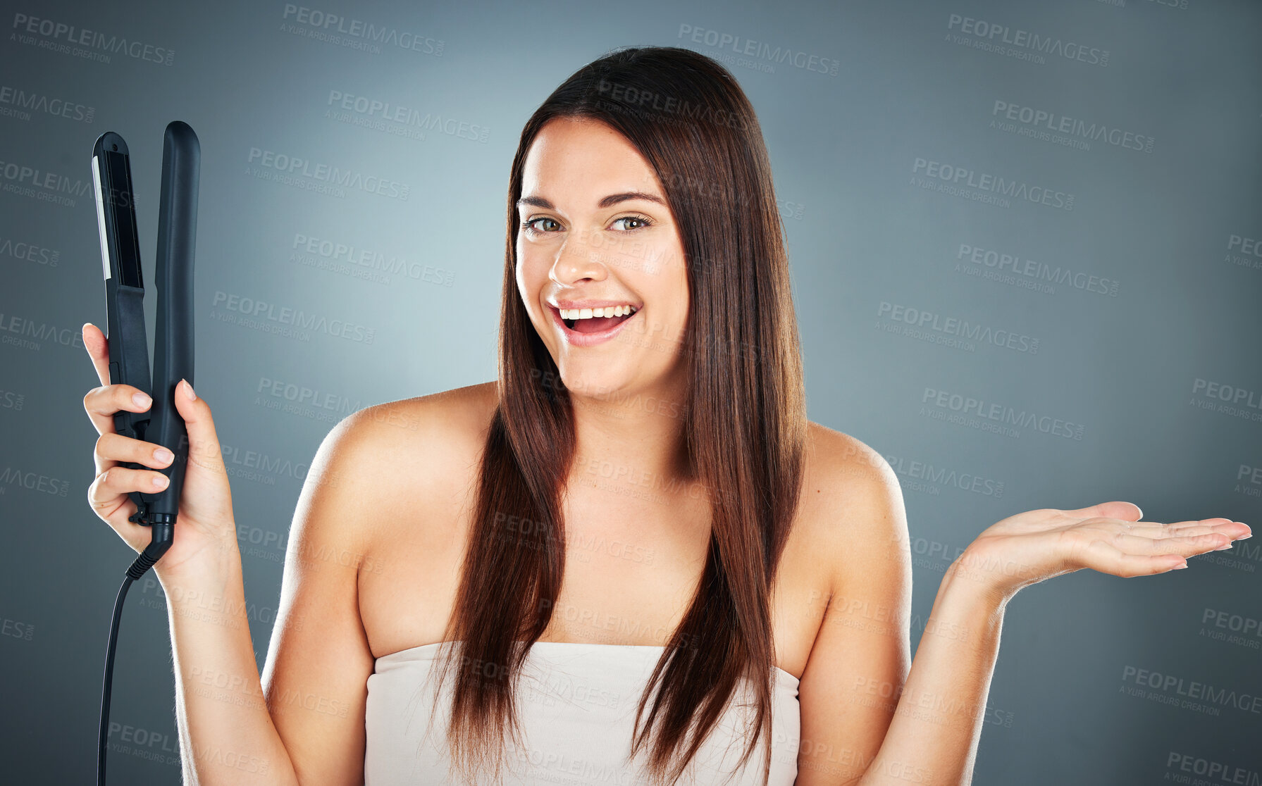 Buy stock photo Hair care, decision and woman with straight hair, product placement and marketing against a blue background in studio. Show, smile and portrait of a model advertising an iron for hair beauty