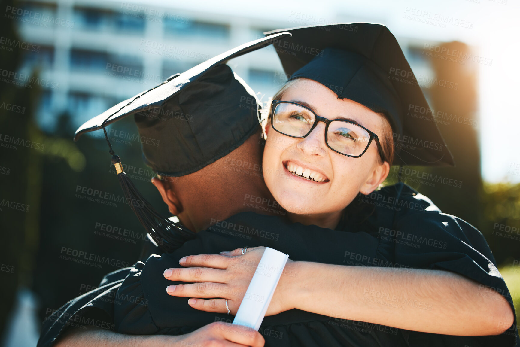 Buy stock photo Hug, graduation and student achievement, happy or smile for success outdoor in gown. Graduate, academic or embrace for diploma, happiness or certificate completed at university, college and education