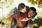 Piggy back, couple and love in park, smile and happy on date, romance and fun together in spring nature. Interracial man and woman happiness, play or relationship outdoor in forest, care or woods