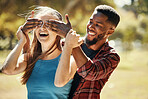 Diverse, couple and man and surprise woman by covering her eyes in a nature park. Shock, wow and people having fun for anniversary surprise in a natural evironment with boyfriend and girlfriend 