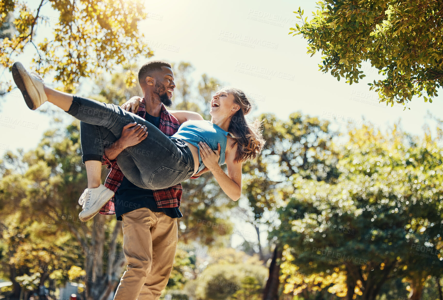 Buy stock photo Young interracial couple, park and man carrying woman on summer date in garden, sunshine fun or relax, love and care together. Happy couple, smile and diversity people in nature for relationship play