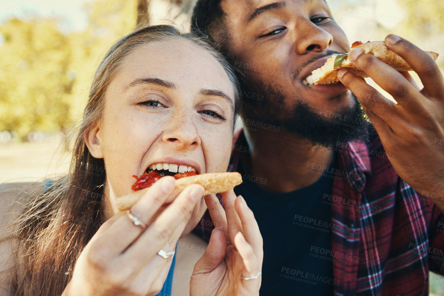 Buy stock photo Pizza, love and happy couple eating fast food while on a date together in nature in a garden. Hungry, food and portrait of a interracial man and woman enjoying an outdoor lunch meal in a field.