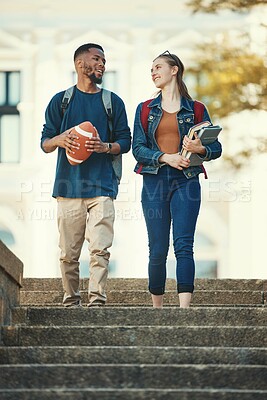 Buy stock photo Couple, friends or students walking in stairs of university, college or campus with books or football ball. Education, sports or man and woman with communication, networking or school study review
