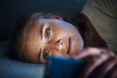 Buy stock photo Night, phone and young woman on sofa to check social media, browsing internet and online content. Technology, mobile app and girl with smartphone for texting, chatting and conversation lying on couch