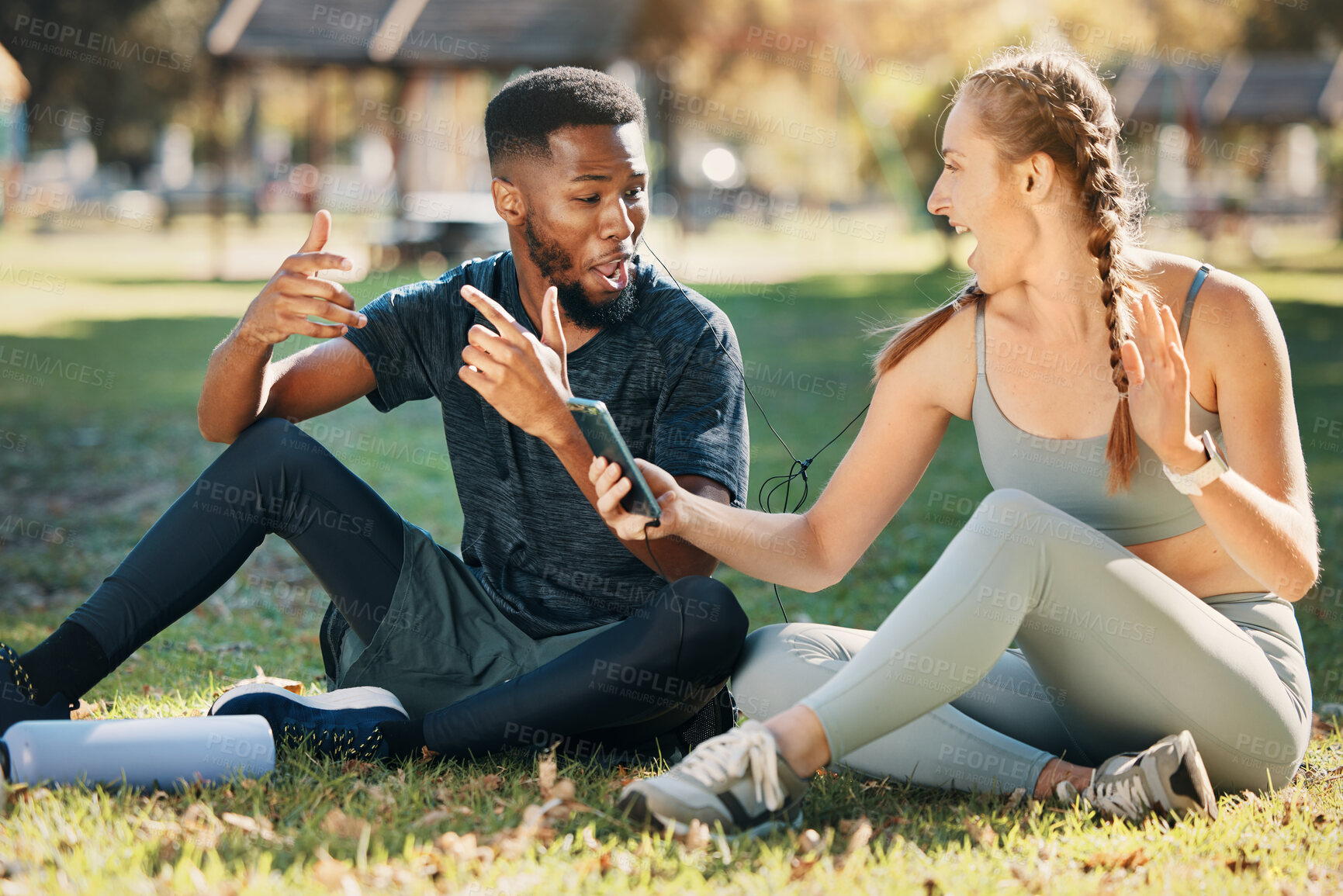Buy stock photo Music, phone and earphone couple in park on fitness run break rap, singing and listen together. Streaming, tech and interracial people listening to feel good beats with mobile app to relax.
