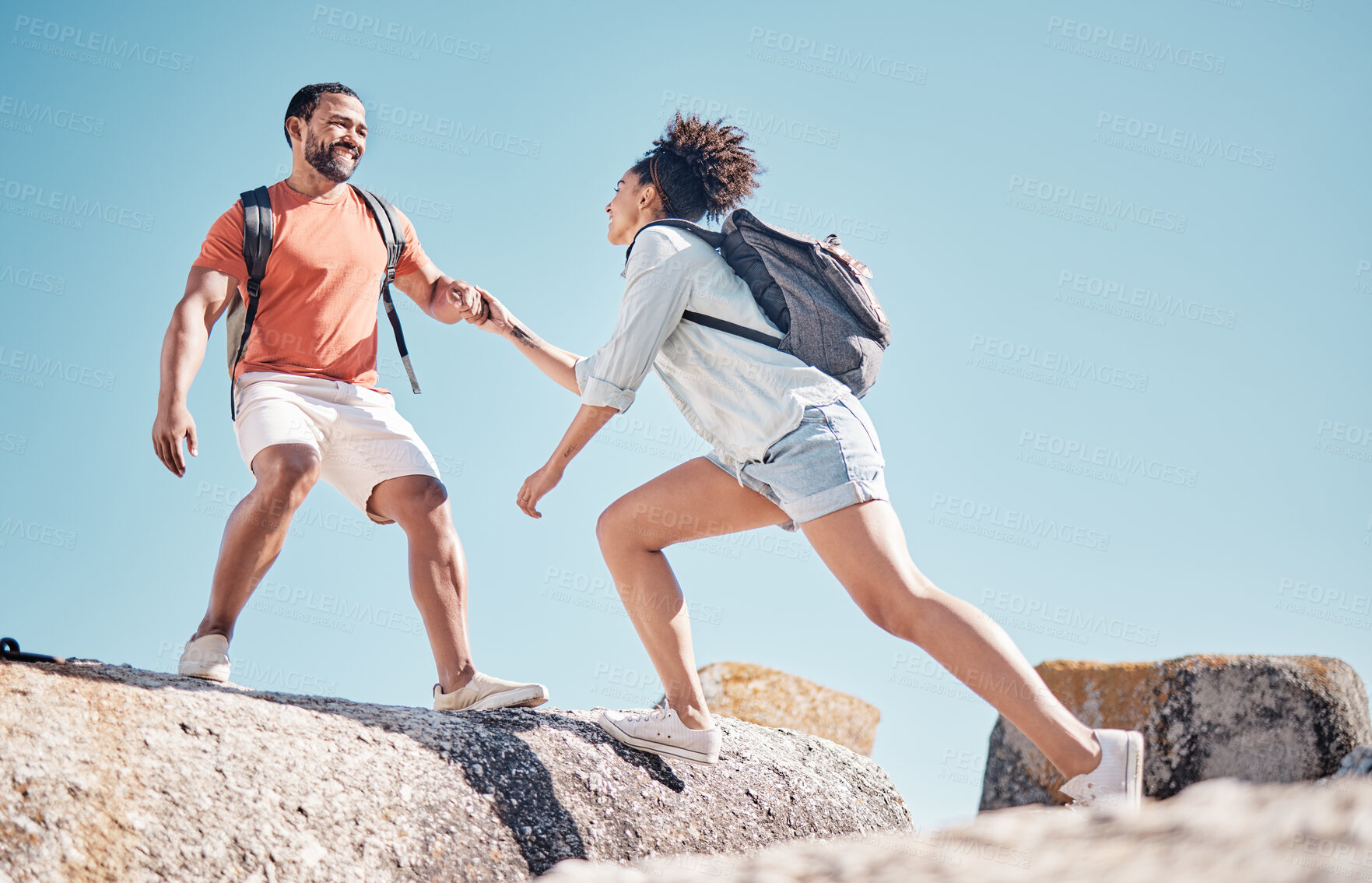 Buy stock photo Helping hand, couple and rock climbing or hiking in nature on vacation, holiday or trip. Teamwork, support and traveling man and woman outdoors in countryside mountain climbing, exercise or workout.