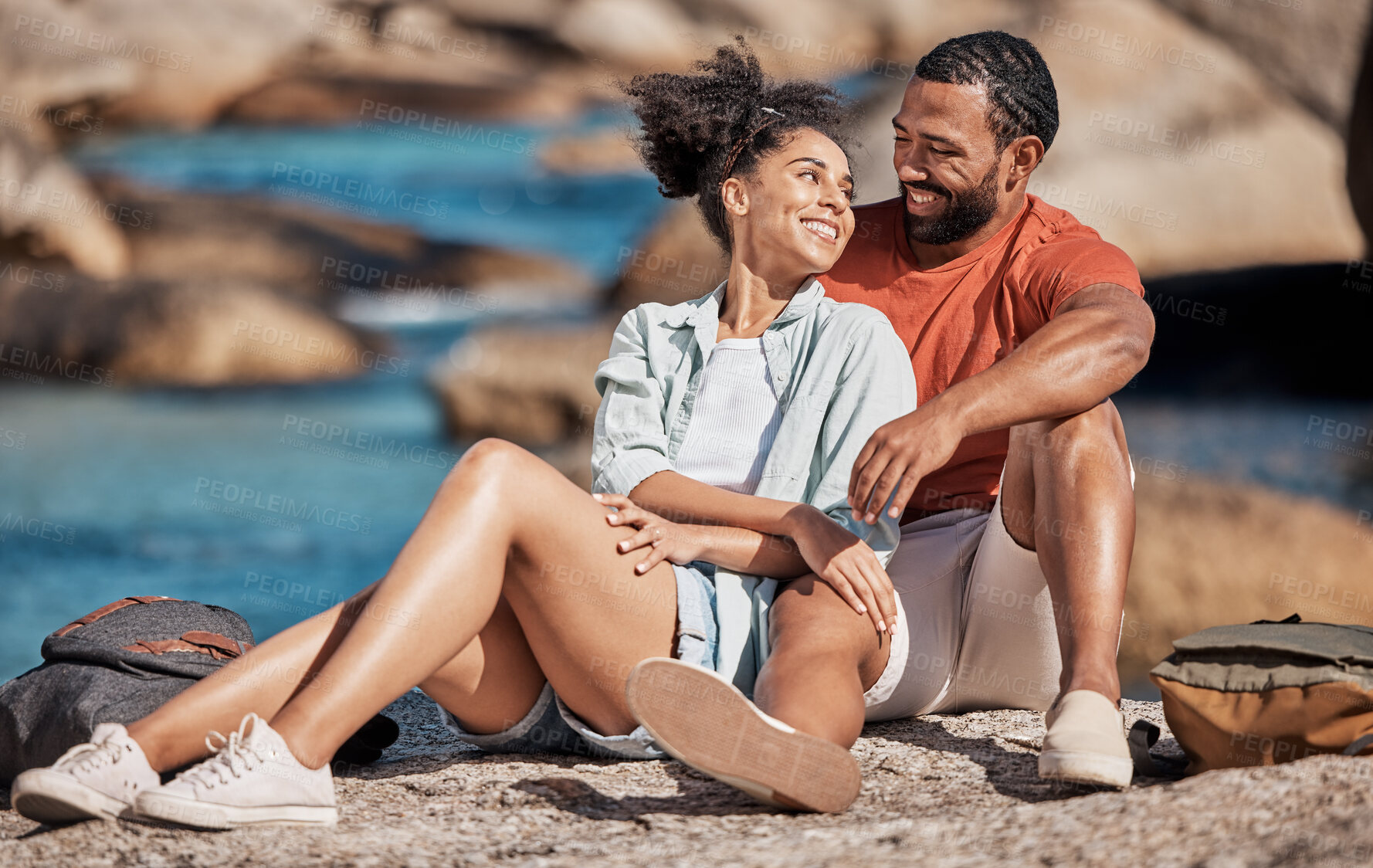 Buy stock photo Beach, date and love with a black couple by the ocean or sea together during summer vacation. Water, travel and happy with a man and woman bonding on the coast while dating or enjoying a holiday