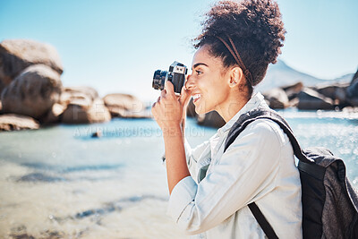 Buy stock photo Photographer, woman and camera at beach for travel vacation or holiday in summer sun. Tourist, happy photography and black woman shooting pictures on sea sand for outdoor lifestyle in sunshine