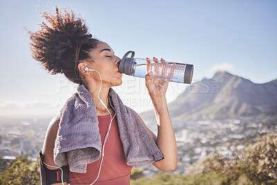 Buy stock photo Music, workout and woman drinking water after exercise at sunrise along mountain, wellness and training on blue sky. Radio, water and black woman stop for break from fitness, running and cardio run