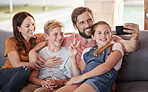 Phone, selfie and happy family on a sofa in the living room relaxing together at their modern house. Happiness, smile and parents taking a picture with their children on a smartphone in their lounge.