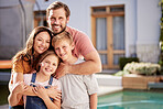 Happy family, relax outside house and outdoor with children, mom and dad smile with love by pool together. Portrait of mother, father and young kids hug together outside a modern home summer bonding 