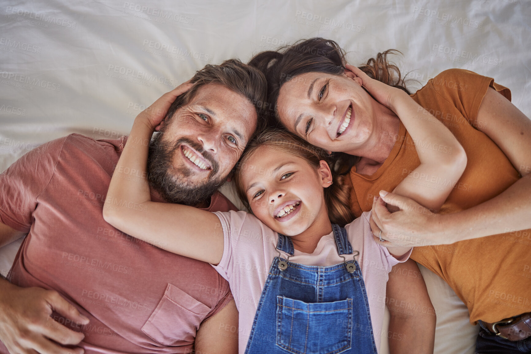 Buy stock photo Family, portrait and relax in bed by girl and parents resting from above, happy and smile in home together. Happy family, love and face of child with mom and dad in bedroom for bond and hug