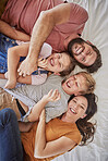 Happy family, love and relax in bed with children and parents laughing, bond and resting in their home together. Parents, kids and laughter in a bedroom by family enjoying a lazy day indoors at home