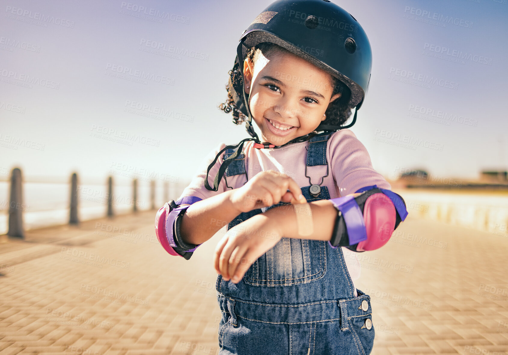 Buy stock photo Skating injury, first aid or child portrait with bandage bruise from skate, cycling or accident in street. Happy, smile or girl with helmet for exercise, wellness health at beach, sea or ocean