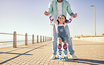 Girl, dad and park for skating, learning and hands to hold for balance, care and safety on concrete. Father, child and roller skates with teaching in urban, ocean promenade or walk in summer sunshine