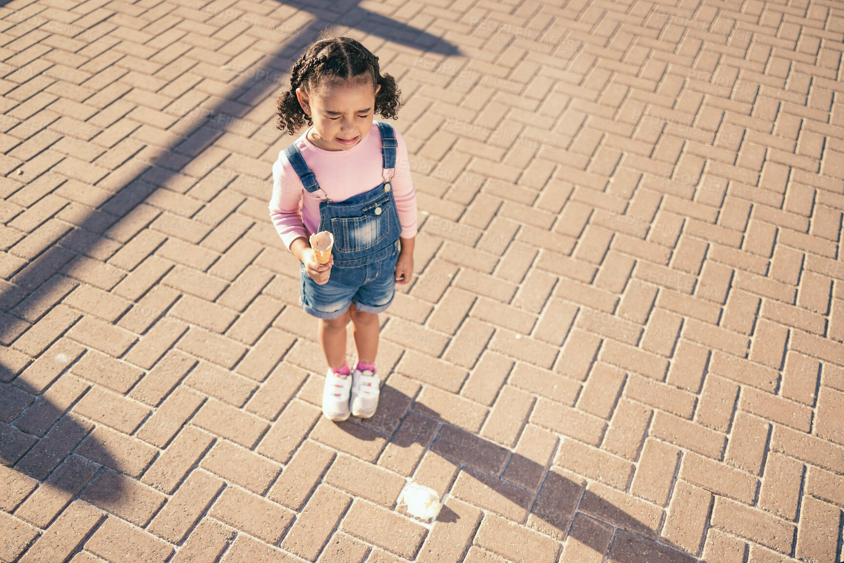 Buy stock photo Crying kid drop ice cream on floor, ground and street in summer, sunshine and outdoors. Sad, unhappy and frustrated girl child in tears for icecream accident, messy dessert mistake and candy problem 