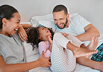 Family, parents and girl happy on bed, smile, laugh and bonding on weekend. Mom, dad or couple with kid happiness and love in pajamas, morning and being playful, care and fun together in bedroom.