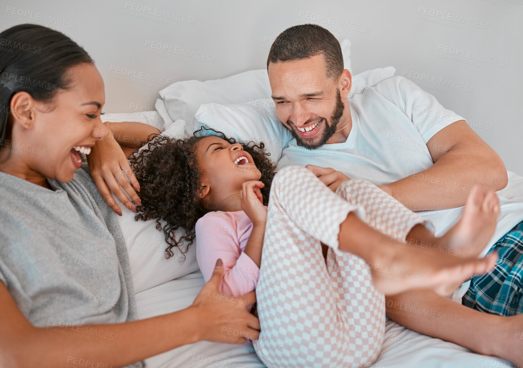 Buy stock photo Family, parents and girl happy on bed, smile, laugh and bonding on weekend. Mom, dad or couple with kid happiness and love in pajamas, morning and being playful, care and fun together in bedroom.