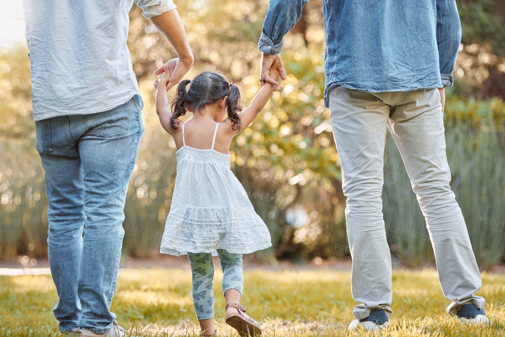 Buy stock photo Holding hands, park and girl with father and grandfather walking, support and trust in nature. Peace, love and back of a child with family men on a walk on a field in the countryside in summer